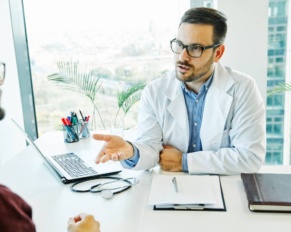 Portrait of a young doctor talking to his patient in his office. healthcare and medicine concept