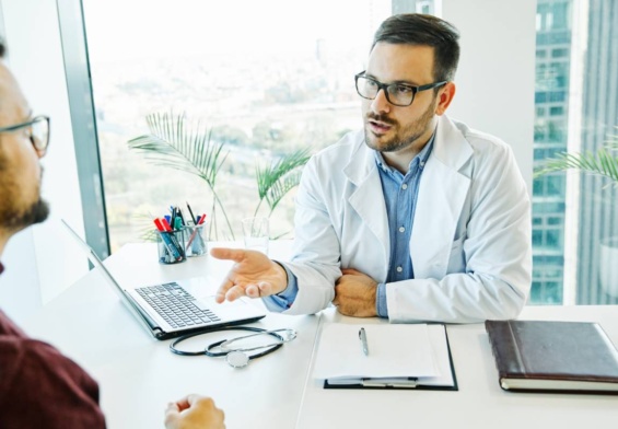Portrait of a young doctor talking to his patient in his office. healthcare and medicine concept